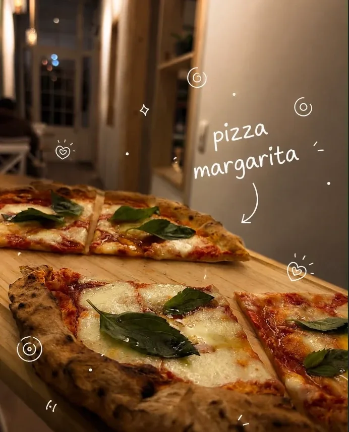Pizza margarita con albahaca sobre tabla de madera